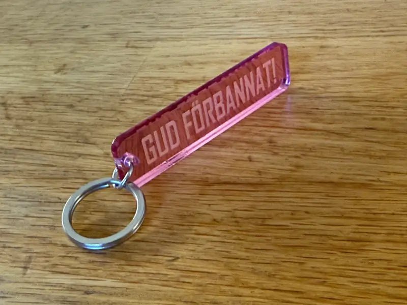 Nyckelring | “Gud förbannat” i Rosa spegelplast - Engwek.se